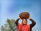 An indian village woman carried wheat basket on head at sky background in india oct 2019