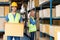 Indian warehouse worker hold cardboard box