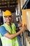 Indian warehouse worker put cardboard box in shelf