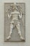 Indian warrior. He has a bow and arrow, a sword on the belt, mask and a snake around his neck. Bas-relief of the facade
