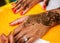 Indian wedding guest having mehndi applied. Traditional henna art.