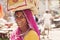 Indian woman caring a shopping bag on her head