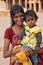 Indian woman with a child standing in the courtyard of Quwwat-Ul-Islam mosque, Qutub Minar, Delhi, India