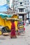 Indian woman in colorful sari carrying hay bale on head