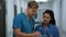 Indian woman doctor consulting man surgeon in hospital corridor close up.