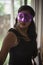 Indian woman in erotic mood standing in front of a glass wall wearing pink eye mask.