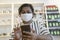 Indian woman with face covered with medical face mask reading her cellphone