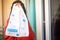 Indian woman girl holding up a milkbasked bag with daily subscription home delivery with face hidden