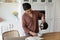 Indian woman holding electric teapot pouring water into ceramic cup