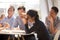 Indian woman laughing eating pizza with diverse coworkers in off