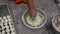 Indian woman is preparing mixture Daler bori in a bowl in sunny day. It is a form of dried lentil dumplings popular in Bengali