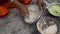 Indian woman is preparing mixture Daler bori in a bowl in sunny day. It is a form of dried lentil dumplings popular in Bengali