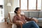 Indian woman relaxing on comfy armchair in cozy living room