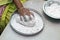 An Indian woman scooping flour/rice powder for making breads