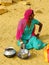 Indian woman sitting in a sand in a small village in Thar desert