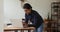 Indian woman standing leaned desk texting on laptop keyboard