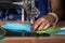 Indian woman working on old sewing machine - making homemade face masks against coronavirus or covid19 spreading, closeup detail