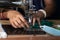 Indian woman working on old sewing machine - making homemade face masks against coronavirus or covid19 spreading, closeup detail