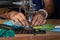 Indian woman working on old sewing machine - making homemade face masks against coronavirus or covid19 spreading, closeup detail