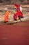 Indian women in colorful saris standing at the edge of red pond, Ranthambore Fort, India