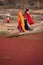 Indian women in colorful saris standing at the edge of red pond, Ranthambore Fort, India