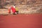 Indian women in colorful saris standing at the edge of red pond, Ranthambore Fort, India