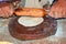 Indian women handling bread with indian cylinder of wood