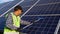 Indian worker cleaning solar panels with brush and water