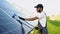 Indian worker cleaning solar panels form dust and dirt