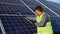 Indian worker cleaning solar panels with mop on the rooftop