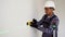 Indian worker measuring walls with laser level tool