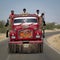 Indian workers in a red truck.