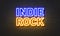 Indie rock neon sign on brick wall background.