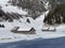 Indigenous alpine huts and wooden cattle stables on Swiss pastures covered with fresh white snow cover, Unterwasser