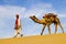 Indigenous Indian Man Walking Through The Desert With His Camel