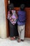 An indigenous Tzotzil Maya girl and boy in traditional dress looking into a house in Zinacantan, Mexico