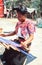 Indigenous Tzotzil maya woman weaving a traditional Huipil at the loom.