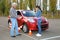 Indignant senior instructor and young woman near car. Passing driving license exam