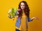 Indignant woman isolated on yellow with wilted flowers