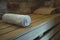 An individual cotton towel on a wooden bench prepared for a sauna client. Comfortable classical steam sauna amenities. Client-orie