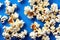 Individual golden flakes of delicious popcorn scattered on table.