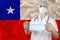 Individual medical mask in the hands of a doctor against the background of the Chile national flag, concept of protection against