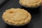 Individual steak pies in foil with a pastry topping