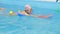 Individual swimming lesson with a personal trainer in an indoor pool. Happy preschool girl is learning to swim with pool