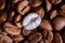 Individuality, standing out from a crowd concept, close up of a single bright, gold coffee bean over many dark ones with copy spac