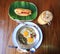 Indochina pan-fried egg with toppings with Baguette bread sandwich with cheese, ham on fresh Green banana leaf and ice coffee
