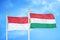 Indonesia and Hungary two flags on flagpoles and blue cloudy sky