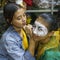 Indonesia, June 13 2022 - Men paint their faces in preparation for going on stage