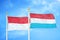 Indonesia and Luxembourg two flags on flagpoles and blue cloudy sky