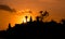 Indonesia temple shape at sunset with orange sky and a ray of light passing through the temple and a person praying and thinking